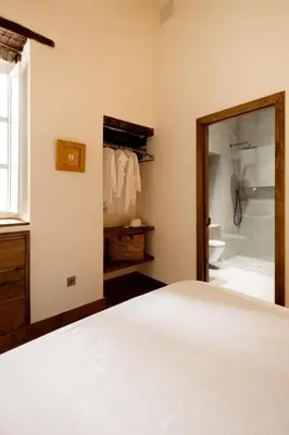 a bedroom with a bed and a bathroom with a shower at La Posada de Juan in Cádiz