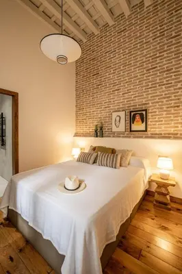 a bedroom with a large white bed with a hat on it at La Posada de Juan in Cádiz