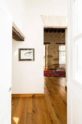 a living room with white walls and wood floors at La Posada de Juan in Cádiz