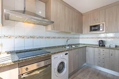 a kitchen with a washing machine and a sink at RONDA DE MULEROS 6 in Jerez de la Frontera