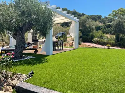 a garden with a white pergola and a green lawn at Villa exclusiva con piscina privada, La Tina Golf in Arcos de la Frontera