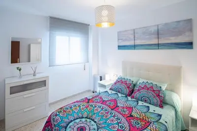 a bedroom with a large bed with colorful pillows at Esencia de Cádiz Entre la Viña y el mercado in Cádiz