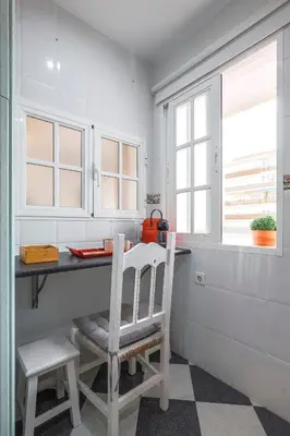 a kitchen with a table and two chairs and a window at Un respiro en cádiz playa victoria 1 hab y salón con sofa cama in Cádiz