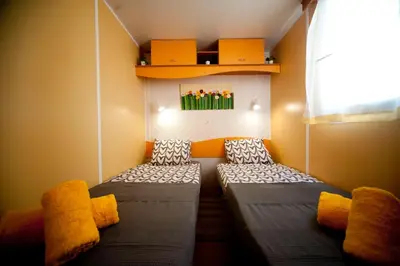 two beds in a small room with a window at Cortijo Flamingos in Chiclana de la Frontera