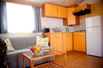 a living room with a couch and a table in a kitchen at Cortijo Flamingos in Chiclana de la Frontera