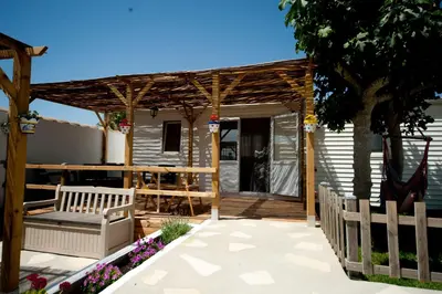a wooden pergola with a bench on a patio at Cortijo Flamingos in Chiclana de la Frontera