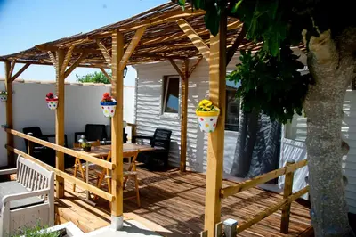 a wooden deck with a pergola with ice cream cones at Cortijo Flamingos in Chiclana de la Frontera