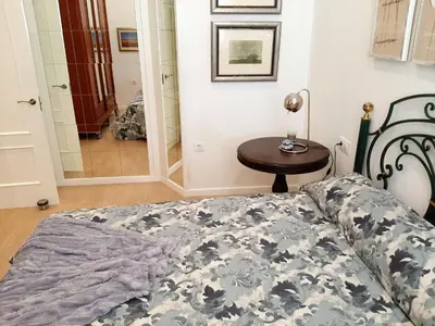 a bed with two blue pillows on top of it at Cozy Apartment in Cádiz with Terrace in Cádiz