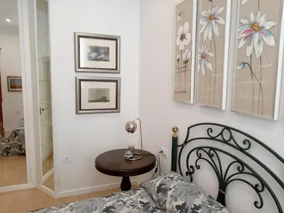 a bedroom with a bed and a table with a lamp at Cozy Apartment in Cádiz with Terrace in Cádiz