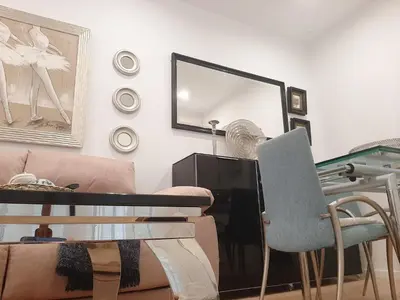 a living room with a table and a mirror at Cozy Apartment in Cádiz with Terrace in Cádiz