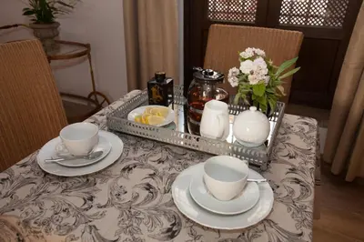 a table with plates and cups and a tray with flowers at Patios de la Riva in Jerez de la Frontera
