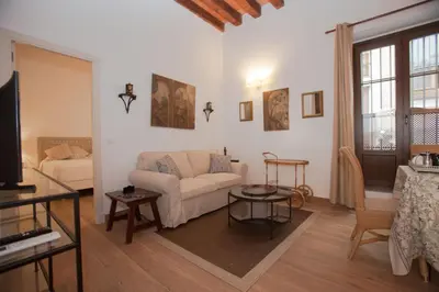a living room with a white couch and a piano at Patios de la Riva in Jerez de la Frontera