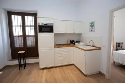 a small kitchen with white cabinets and a sink at Patios de la Riva in Jerez de la Frontera