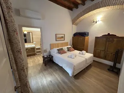a bedroom with a white bed and a bathroom at Patios de la Riva in Jerez de la Frontera