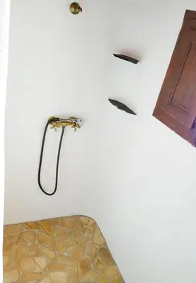 a bathroom with a shower in a white wall at La Casita de Los Alambiques in Chiclana de la Frontera