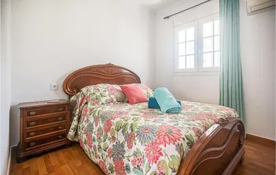a bedroom with a bed and a dresser and a window at Lovely Home In Chiclana De La Fronter in Cádiz