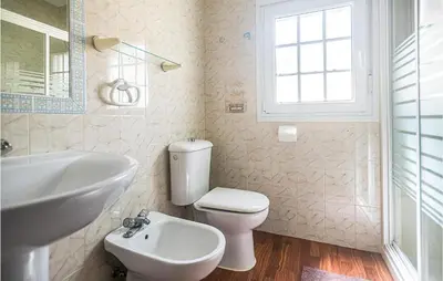 a bathroom with a white toilet and a sink at Lovely Home In Chiclana De La Fronter in Cádiz