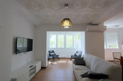 a living room with a couch and a tv at Apartamento Mercedes Céntrico Playa in Sanlúcar de Barrameda