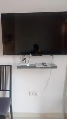 a shelf with a television on a wall at Apartamento Mercedes Céntrico Playa in Sanlúcar de Barrameda
