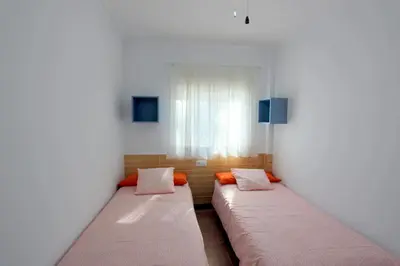two beds in a room with a window at Apartamento Mercedes Céntrico Playa in Sanlúcar de Barrameda