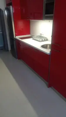 a red kitchen with a sink and red cabinets at Apartamento Mercedes Céntrico Playa in Sanlúcar de Barrameda