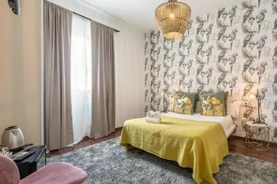 a bedroom with a bed with a yellow blanket at Catedral Suites Jerez in Jerez de la Frontera