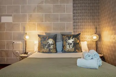 a bedroom with a bed with towels on it at Catedral Suites Jerez in Jerez de la Frontera