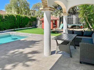 a patio with a table and a bench next to a pool at Villa Alamos Jerez I Piscina Salada Climatizada I BBQ I Jardines I 850m2 in Jerez de la Frontera