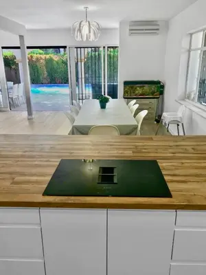 a kitchen and living room with a table and a dining room at Villa Alamos Jerez I Piscina Salada Climatizada I BBQ I Jardines I 850m2 in Jerez de la Frontera