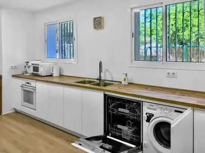 a kitchen with a sink and a washing machine in it at Villa Alamos Jerez I Piscina Salada Climatizada I BBQ I Jardines I 850m2 in Jerez de la Frontera