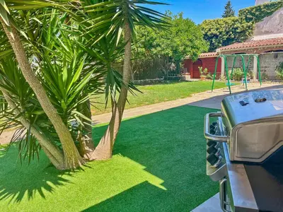 a park with a playground with a palm tree at Villa Alamos Jerez I Piscina Salada Climatizada I BBQ I Jardines I 850m2 in Jerez de la Frontera