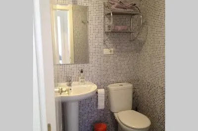 a small bathroom with a toilet and a sink at Apartamento jardin Sanlucar in Sanlúcar de Barrameda