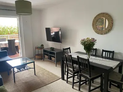 a dining room with a table and chairs and a television at Apartamento jardin Sanlucar in Sanlúcar de Barrameda