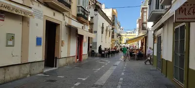 a group of people walking down a narrow street at Apartamento la Capillita in Sanlúcar de Barrameda