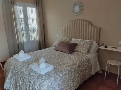a bedroom with a bed with two towels on it at Apartamento la Capillita in Sanlúcar de Barrameda