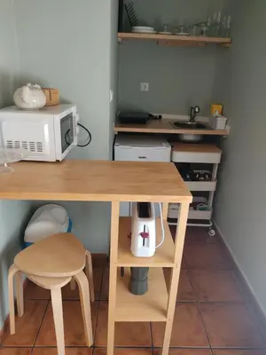 a kitchen with a wooden table and a microwave at Apartamento la Capillita in Sanlúcar de Barrameda
