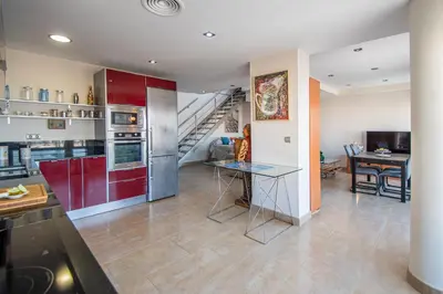 a kitchen with red cabinets and a staircase at Loft Space - Time in Cádiz in Cádiz