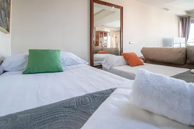 a room with two beds and a couch and a mirror at Loft Space - Time in Cádiz in Cádiz