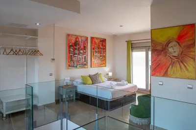 a living room with a bed and a glass table at Loft Space - Time in Cádiz in Cádiz