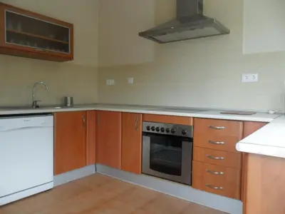 a kitchen with wooden cabinets and a stove top oven at Villas Aloha Valdelagrana in El Puerto de Santa María