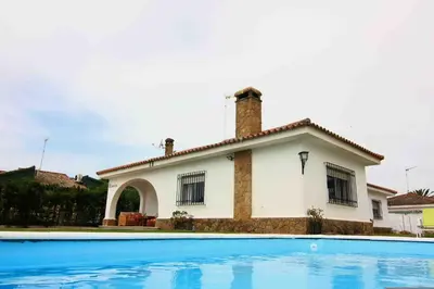a house with a swimming pool in front of it at Villas Aloha Valdelagrana in El Puerto de Santa María