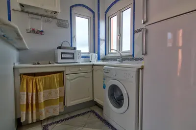 a kitchen with a washing machine and a sink at Apartamentos Aloha2 El Puerto de Santa Maria in El Puerto de Santa María