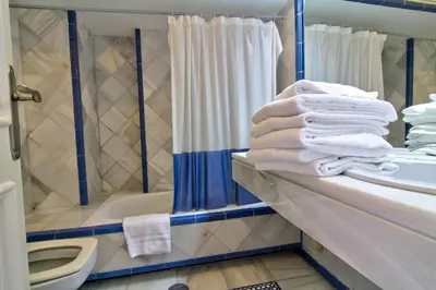 a bathroom with a shower and a pile of towels at Apartamentos Aloha2 El Puerto de Santa Maria in El Puerto de Santa María