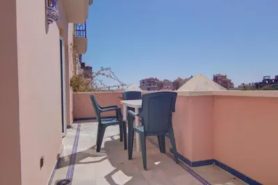 a patio with chairs and a table on a balcony at Apartamentos Aloha2 El Puerto de Santa Maria in El Puerto de Santa María