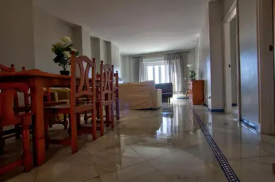 a living room with a dining room table and chairs at Apartamentos Aloha2 El Puerto de Santa Maria in El Puerto de Santa María