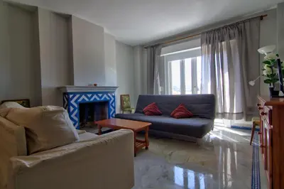 a living room with a couch and a fireplace at Apartamentos Aloha2 El Puerto de Santa Maria in El Puerto de Santa María
