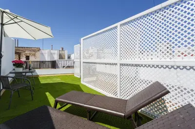 a balcony with a bench and a table and an umbrella at Apartamentos LOTO y LIZ by Cadiz4Rentals in Cádiz