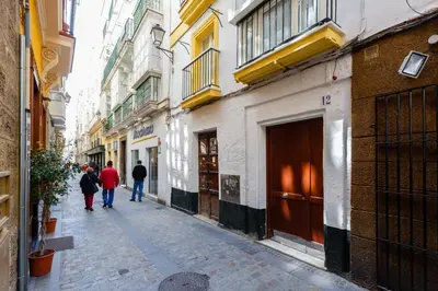 a group of people walking down a street with buildings at Apartamentos LOTO y LIZ by Cadiz4Rentals in Cádiz