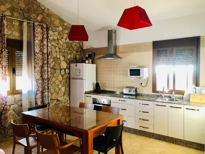 a kitchen with a table and a white refrigerator at Casa Con Encanto Solo Familia in Conil de la Frontera