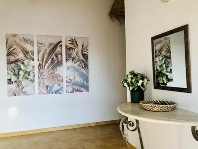 a room with three paintings on the wall and a table at Casa Con Encanto Solo Familia in Conil de la Frontera